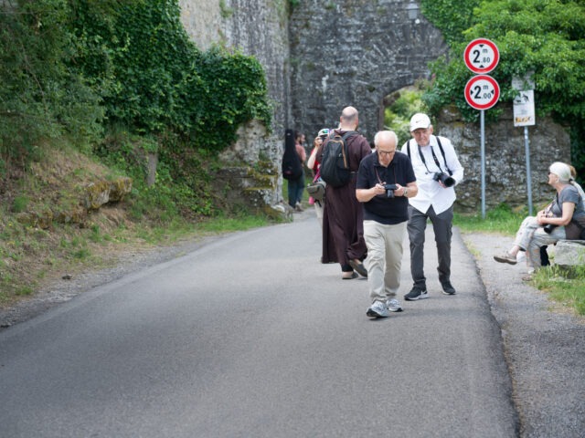 A couple of guys and a monk meet outside the gates of Cortona